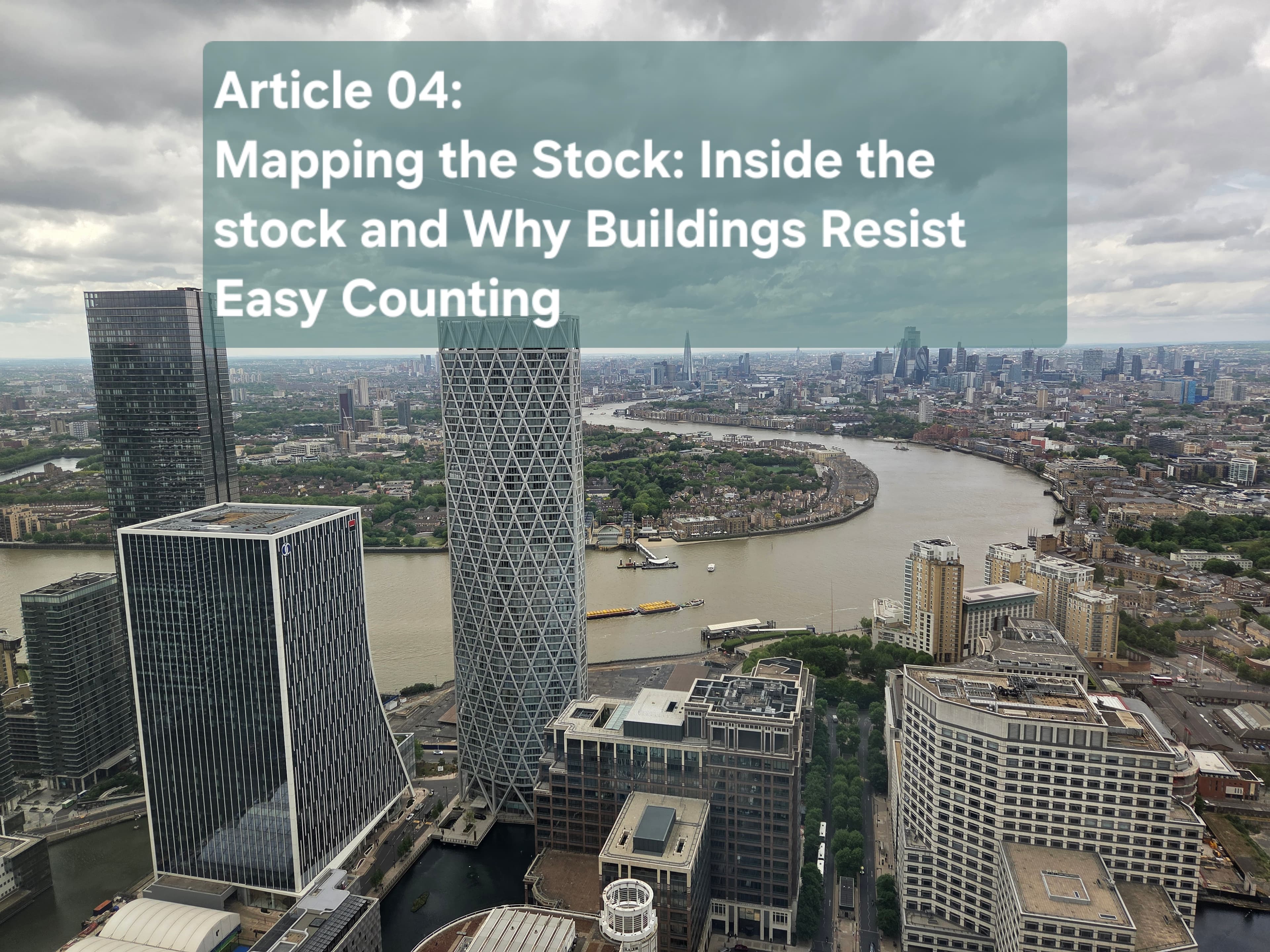 Aerial view of Canary Wharf office towers beside the River Thames under a cloudy sky, the title card for Article 04 on mapping the office stock and why buildings resist easy counting.